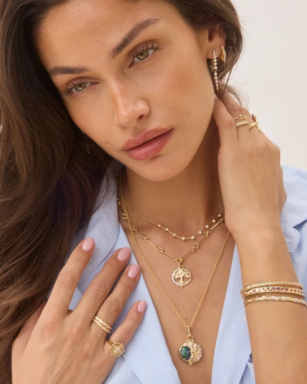 Three Stories Textured Oval Chain styled with a pendant and layered gold necklaces