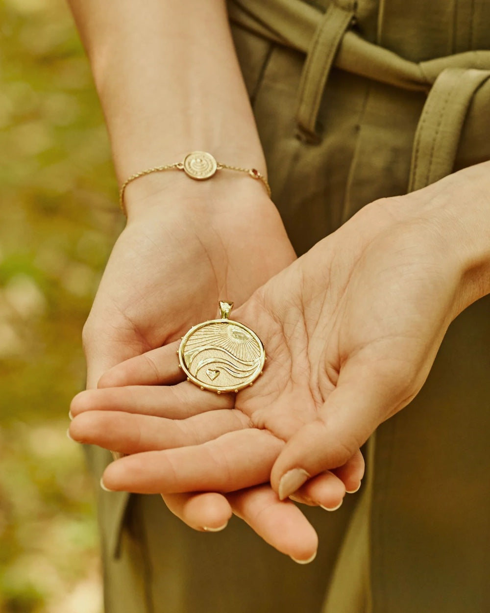 Jane Win Love–Courage–Strength original coin pendant shown in hand for scale