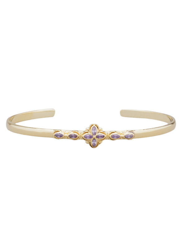 The Haley Bracelet from Monarch Market is a thin gold bangle with an open-ended design, featuring intricate center details and small purple semi-precious stones in a symmetrical pattern, inspired by a bohemian color palette.