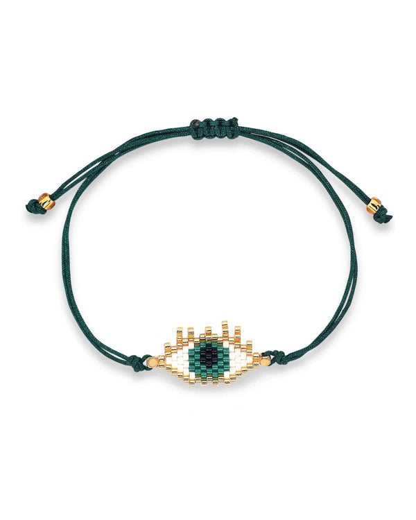 The Katrina Miyuki Eye Bracelet by Oiya is a dark green adjustable cord bracelet with a handmade beaded evil eye design in green, white, and gold at the center.