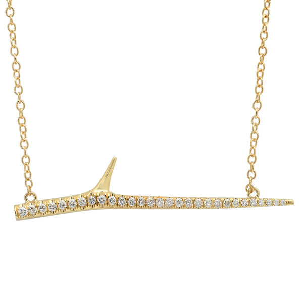 The Elisabeth Bell Thorn Necklace features a gold pendant resembling a slender branch, adorned with shimmering diamonds and a single protruding thorn. Delicately handcrafted in Los Angeles, its elegant design is perfectly complemented by the chain.