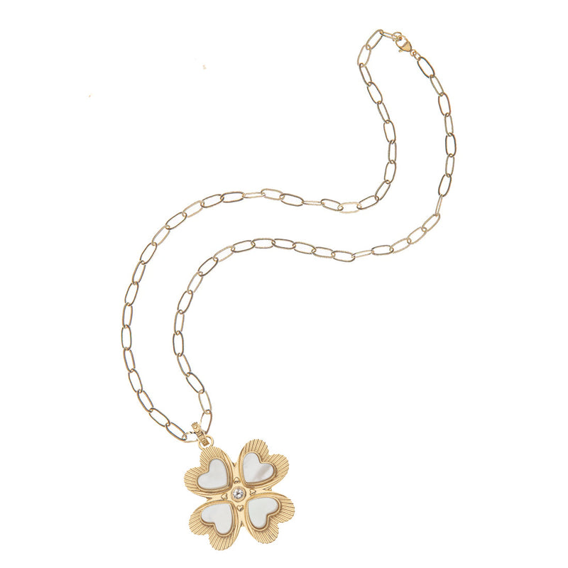 The Lucky in Love Clover Pendant with Mother of Pearl by Jane Win is a gold chain necklace featuring a striking flower-shaped pendant. It showcases four heart-shaped petals with a white center and small pearls at each point, resulting in an elegant clover-like design.