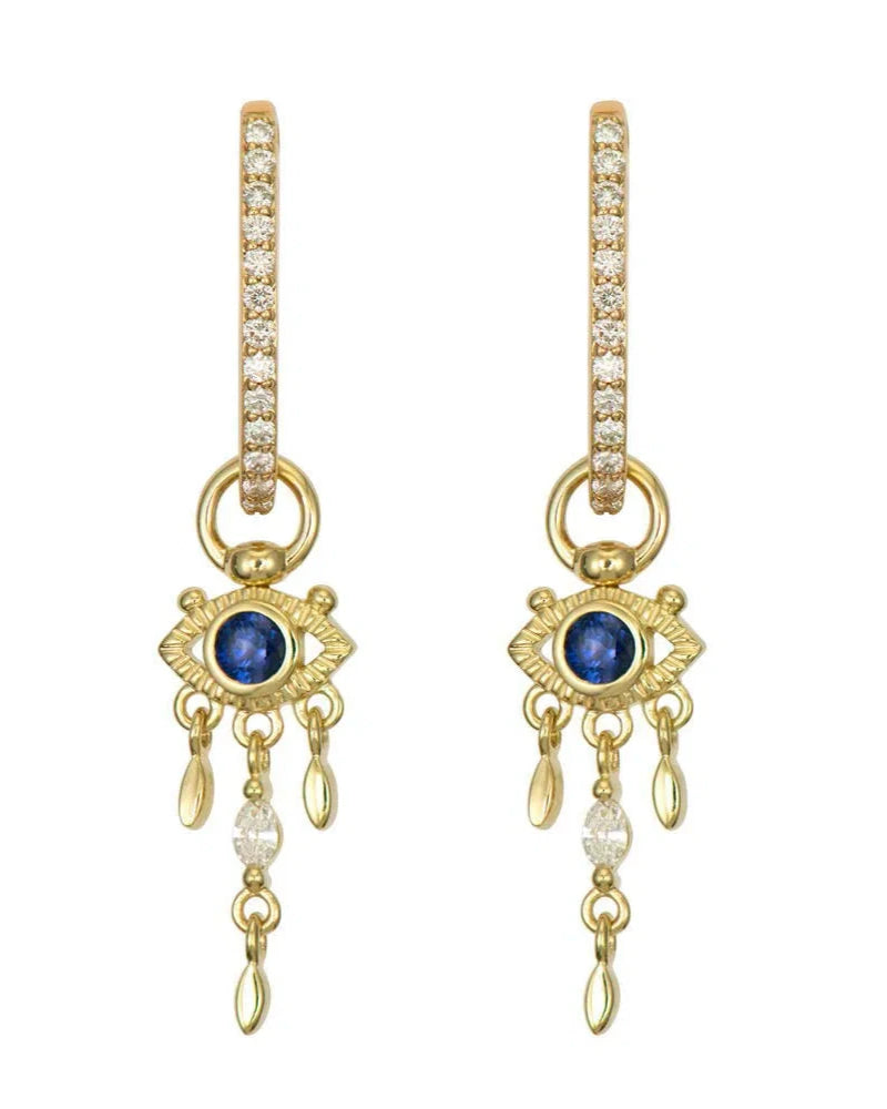 The Open Evil Eye Sapphire Charm earrings by Three Stories Jewelry feature 14K yellow gold hoops with pavé diamonds, open evil eye charms with blue sapphire centers, and dangling gold and diamond drops.