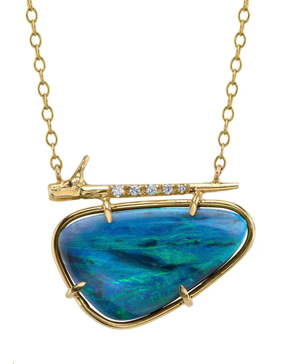 Gold necklace with a heart-shaped blue stone pendant on a white background
