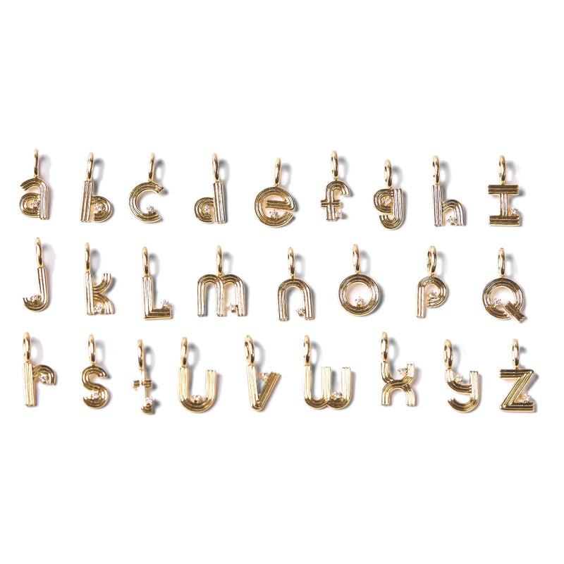 Groovy Diamond Initial Mini Bead Charms by Adina Reyter, crafted in 9K Yellow Gold, are displayed in four rows showcasing the letters a to z. Each charm includes a small loop for simple attachment to chains or bracelets, and they rest gracefully against a plain white background.