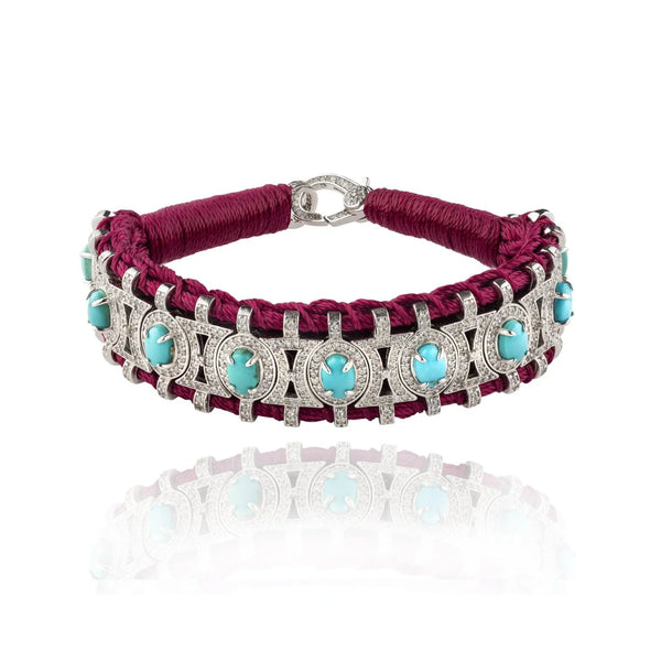 The Van Den Abeele Sao Paulo Turquoise bracelet features a intricate lattice design with turquoise stones and diamond accents. Its deep red woven band and metal clasp add to its elegant appearance, blending the shimmer of diamonds with the vibrant hue of turquoise.