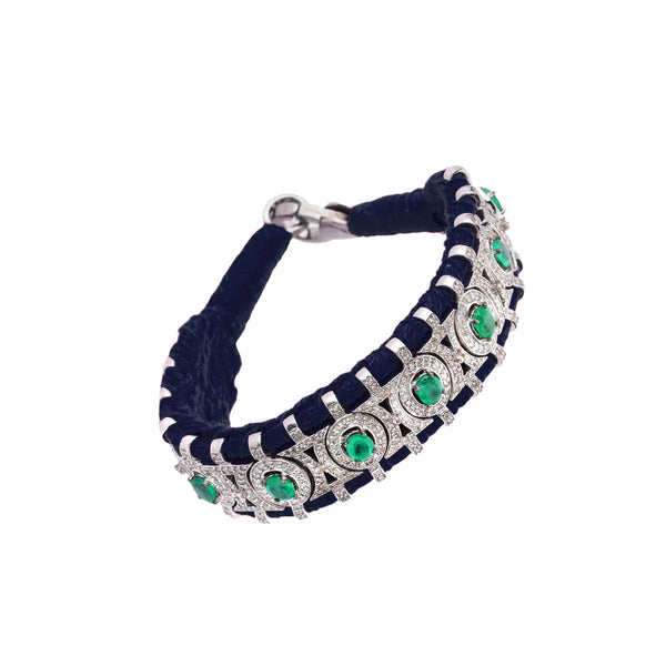 The Sao Paulo Navy and Emeralds bracelet by Van Den Abeele features a blue band with silver accents, sparkling diamonds, and circular green gemstones for an elegant design.