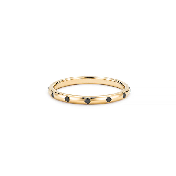 The Eternity Stacker Ring by Kate Collins Jewelry is a strikingly elegant 14k gold band, featuring evenly spaced small black gemstones, perfectly encapsulating the essence of fine jewelry against a plain white background.