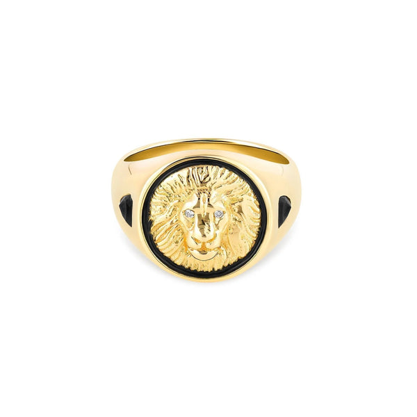 The Courage Signet Ring by Kate Collins Jewelry features a 14k gold design with a majestic lion symbol and diamond eyes for sparkle. Its intricately detailed mane and smooth polished finish are enhanced by black enamel detailing on the sides.