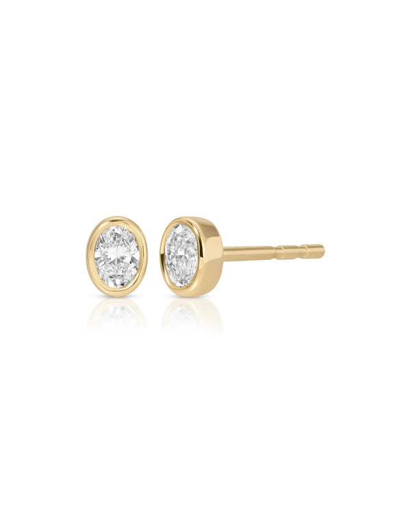 A single bezel set oval diamond stud earring by ef collection, featuring an elegant clear diamond in a smooth gold setting, reminiscent of the Gold Jumbo Disc Charm, displayed on a white background.