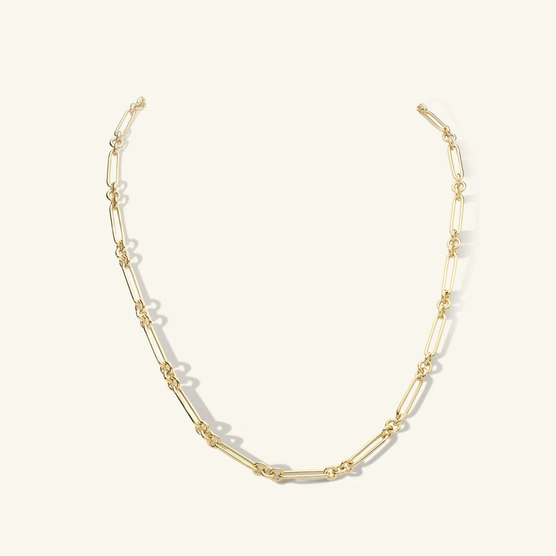 The Esmé Paperclip Chain Necklace by zahava is a 14k gold piece with elongated links and evenly spaced small knots, featuring an elegant connector, set against a plain light background for versatility.