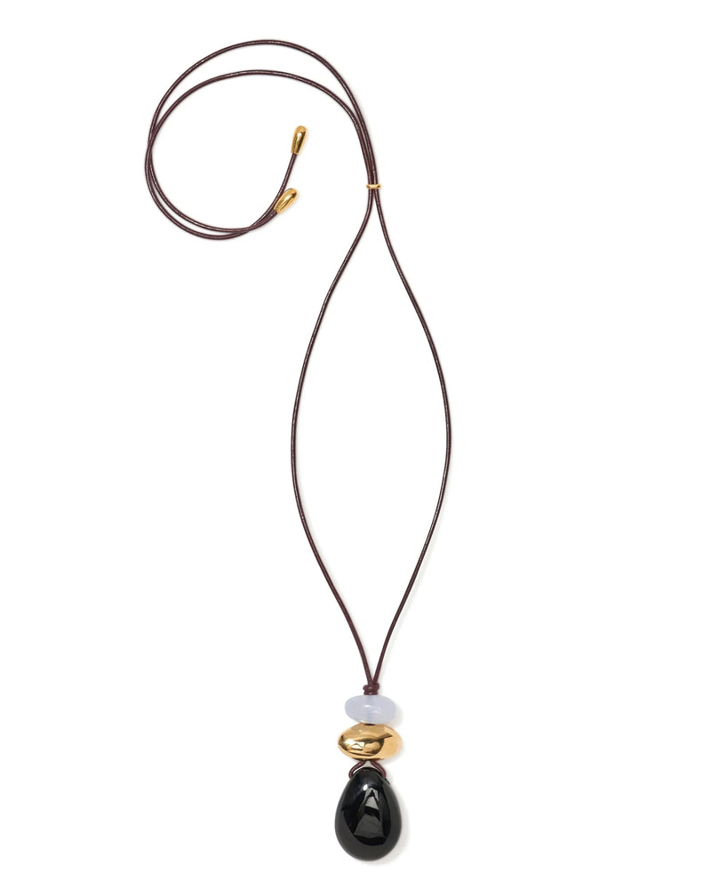 The Museo Cord Necklace by Lizzie Fortunato features a dark brown leather cord with gold-tone tips and a stacked pendant of black onyx, gold-plated brass, and pale lavender beads for an elegant layered look.