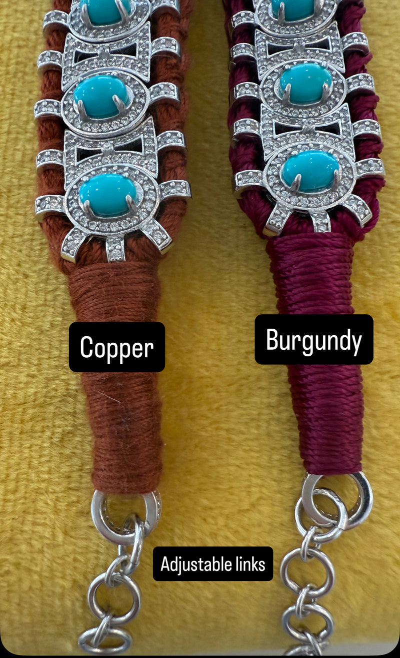 The Van Den Abeele Sao Paulo Turquoise bracelets feature woven designs with turquoise stones and silver details. One has brown thread and copper tones, the other is burgundy with dark red thread; both have adjustable chain links.