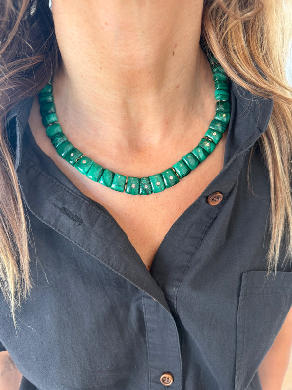 A woman wears the Jen Proudman Mini Cleopatra Collar Necklace—an everyday luxury piece featuring green malachite and diamonds—with a black button-up shirt. Her wavy light brown hair frames her neck on both sides.