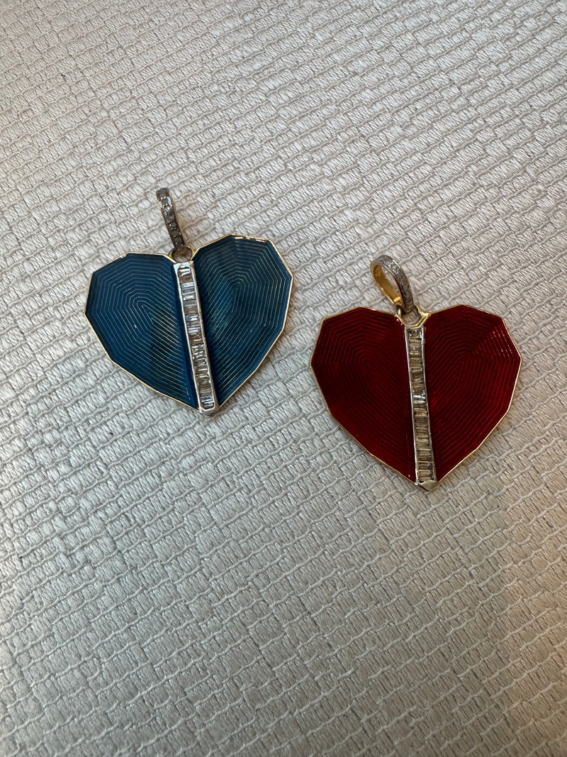 Two heart-shaped pendants on a textured surface from the woods. The left pendant is blue with a vertical line of small stones, and the right is the Red Heart, featuring a similar design. Both have gold-colored frames and chain loops.