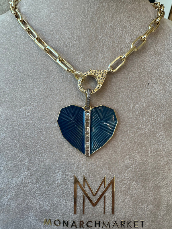 An elegant blue enamel diamond heart pendant necklace by the woods is showcased on a stand with a gold chain, pave diamond bail, and diamond-adorned clasp. The stands base features the Monarch Market logo.