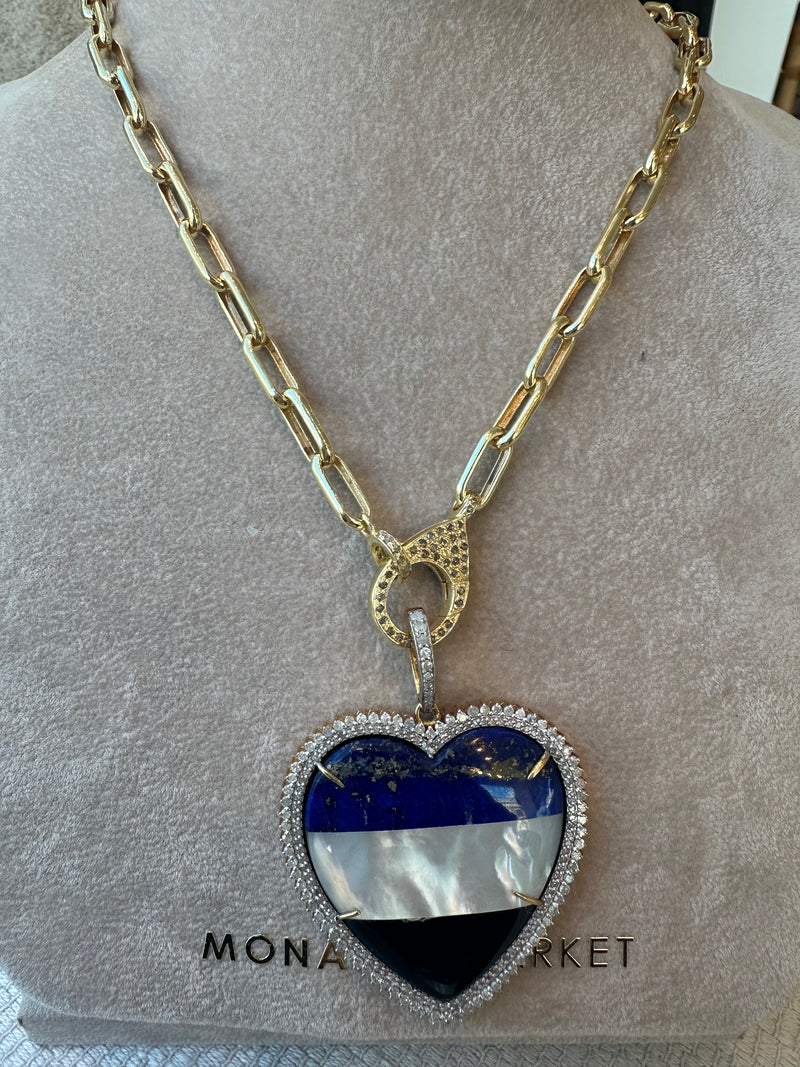 A 10k gold chain necklace by the woods showcases a striped heart pendant with blue, white, and black sections encircled in pave diamonds. An ornate circular connector gracefully suspends the large heart from the chain, adding elegance.