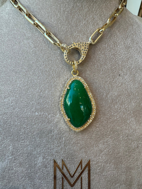 The Green Onyx and Diamond Pendant by the woods is a 10k gold necklace featuring a green onyx pendant encircled by small pave diamonds. Displayed elegantly on a mannequin, it has a toggle clasp with diamond accents.