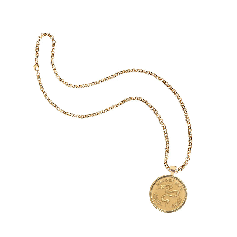 The Jane Win Protection Coin Pendant is a gold chain necklace with a round engraved snake and GARDE LE FOI—a meaningful snake talisman.