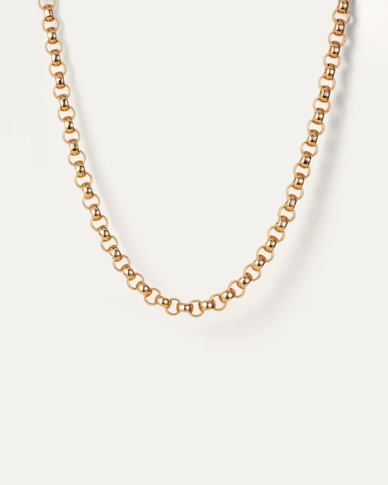 A close-up of the Jenny Bird Rodin Chain necklace, showcasing its interlocking round links on a plain off-white background, highlights a simple yet elegant design.