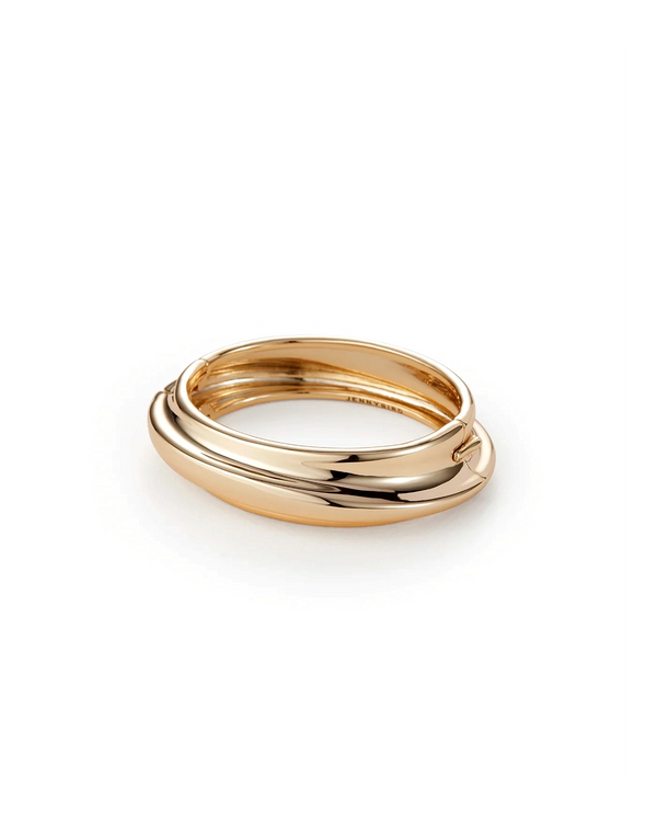 The Lennon Bangle by Jenny Bird features a polished gold tone and a smooth, rounded design, shown against a white background.