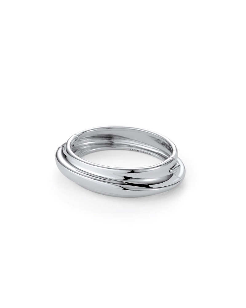 The Lennon Bangle by Jenny Bird features three smooth, interlocking silver bands with a minimalist, organic design, displayed on a white background.