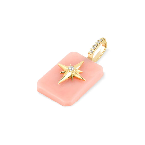 The Emerald Cut Cabochon Charm- Starburst by Kate Collins Jewelry is a rectangular pink opal pendant with a gold starburst, featuring a central white gemstone. The 14k gold loop has small white gemstones, ideal for attaching to a chain.