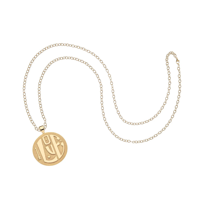 Jane Wins Jumbo LOVE Pendant, a 14k gold plated necklace, features a delicate chain and round pendant with Arabic calligraphy. Engravable for personalization, it exudes elegance and heartfelt sentiments on a white background.