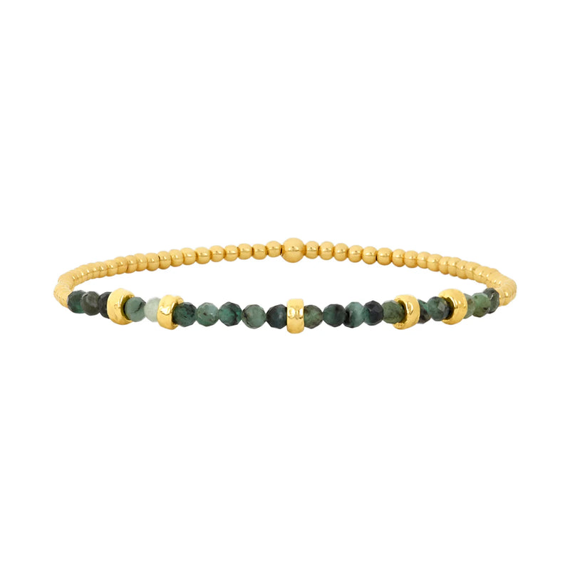 The May Emerald and Rondelle Bracelet by Karen Lazar is a finely crafted piece featuring a strand of small gold beads mixed with dark green emerald beads, all made from 14k yellow gold. The bracelet includes several gold rings as accents among the emerald gemstones, enhancing its elegance. Each bracelet is meticulously handmade in Los Angeles.