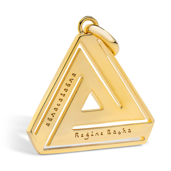 The Aaron Basha Small Abracadabra Triangle Series 4 is a gold-plated triangular pendant featuring a hollow center and engraved inscriptions like abracadabra and a name, symbolizing personal empowerment with its polished finish and round loop for jewelry attachment.