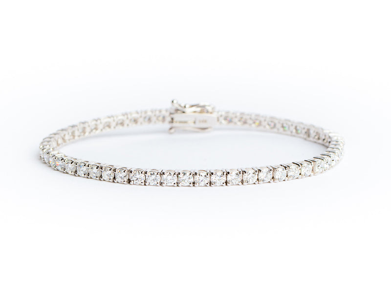 A Lab Grown Tennis Bracelet by Monarch Market, showcasing a silver design with a row of closely set sparkling white diamonds on a white background.