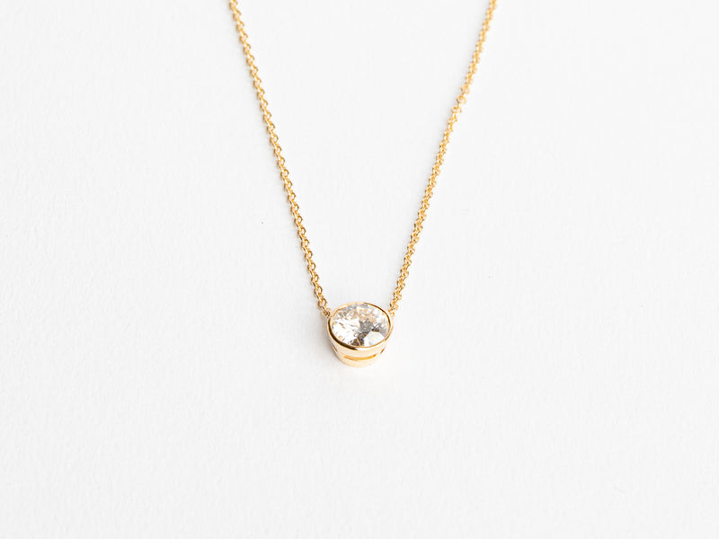 The Lab Grown Small Gold Bezel Necklace by Monarch Market features a round diamond pendant in a minimalist bezel setting and is showcased on a white backdrop, emphasizing its elegance.