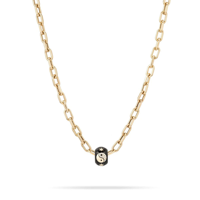 The Adina Reyter Zodiac Ceramic + Diamond Gemini Big Bead is a 14k gold chain necklace with a black bead featuring a gold yin-yang symbol and stars, showcased centered on the chain against a white background.