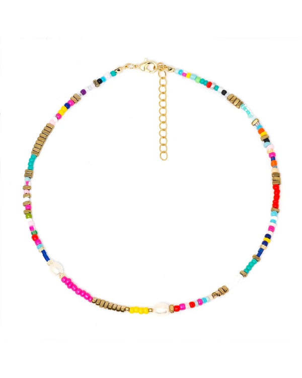 The Mona Pearl Beaded Choker by Oiya features colorful glass and gold-toned beads, two small white pearls, a gold adjustable chain clasp, and a delicate seashell pendant, displayed on a white background.