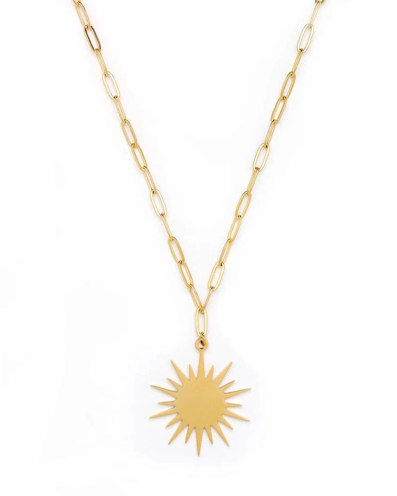 The Leilani Sun Chain Necklace by Oiya features elongated gold links and a sunburst pendant, displayed against a white background for a handmade, unique look.