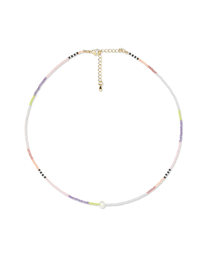The Oiya Issa Pearl Beaded Choker features pastel and neutral beads with a central white bead and a gold adjustable chain clasp. This handmade necklace is perfect for adding charm to any look.