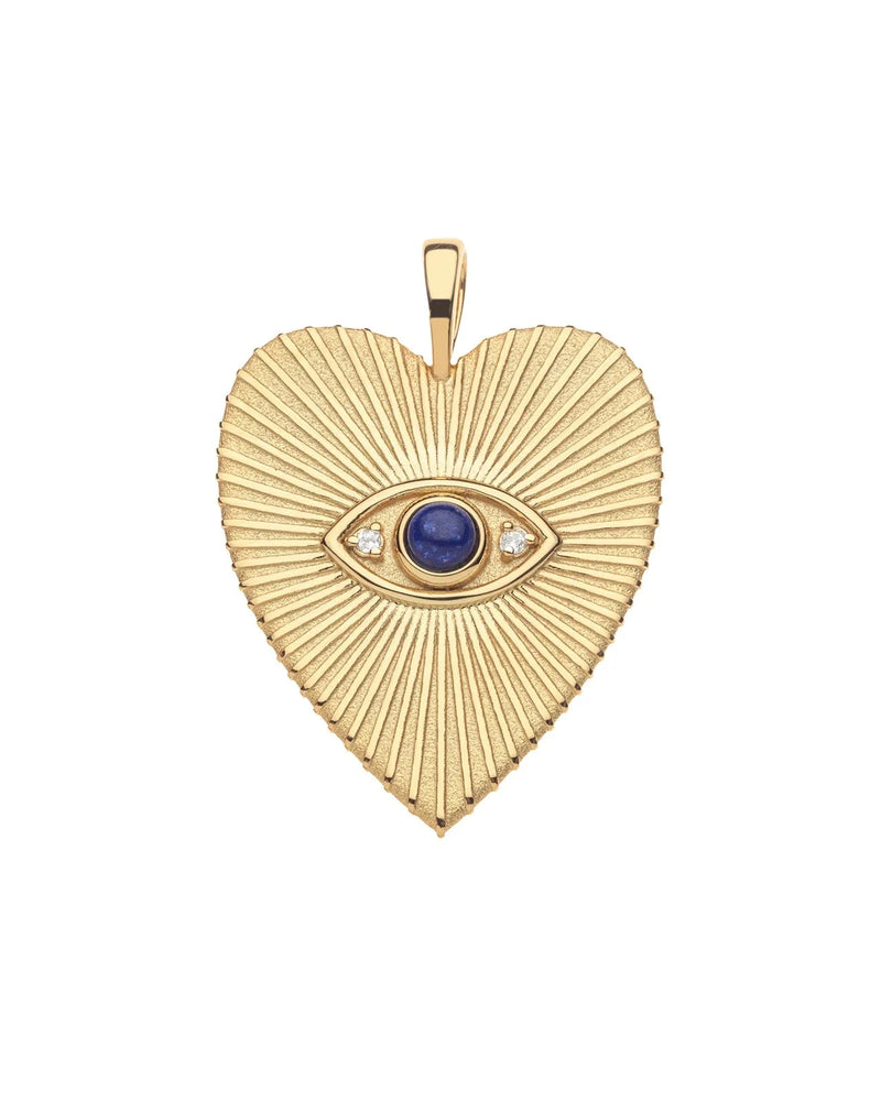 The Jane Win PROTECT Eye On Your Heart Pendant is a gold heart with radiating lines, showcasing an evil eye at the center with a blue lapis iris and two small white stones flanking the eye.
