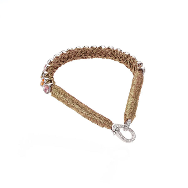 The Rio Brass bracelet by Van Den Abeele is a handmade, gold-toned piece featuring small silver beads and colorful gems for a bohemian charm. Its ornate silver clasp with intricate detailing ensures this accessorys uniqueness.