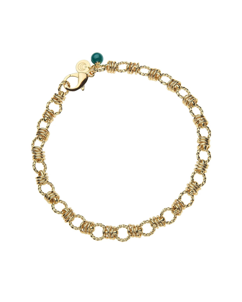 The Rings of Gold Chain with Malachite Bead by Jane Win features interlocking twisted gold links, a lobster clasp, a small round charm, and a malachite bead accent. Shown arranged in a circle on a white background.