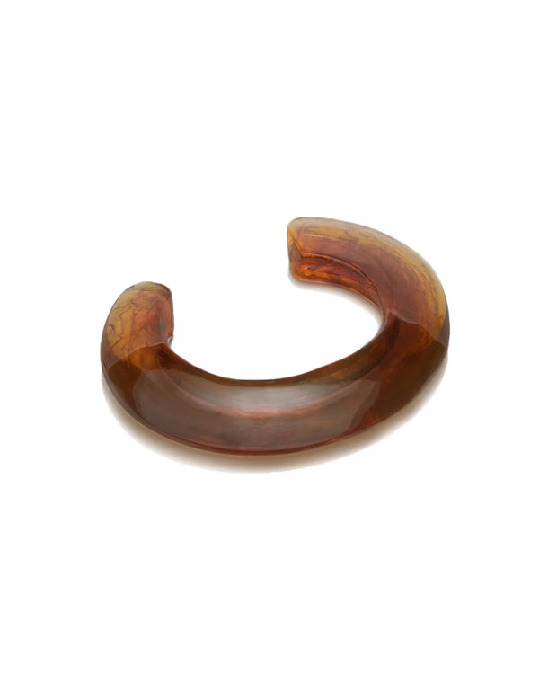 The Lizzie Fortunato Ridge Cuff in Tortoise is a chunky, marbled resin bracelet in a translucent brown open-circular shape—perfect for unique stacking.