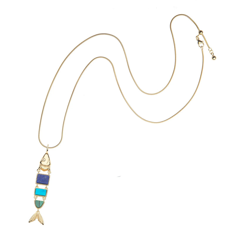 The STRONG Carpe Diem Fish Pendant by Jane Win is a gold-plated necklace with a fish-shaped pendant featuring blue and turquoise geometric segments, gold accents on the head and tail, shown against a white background.
