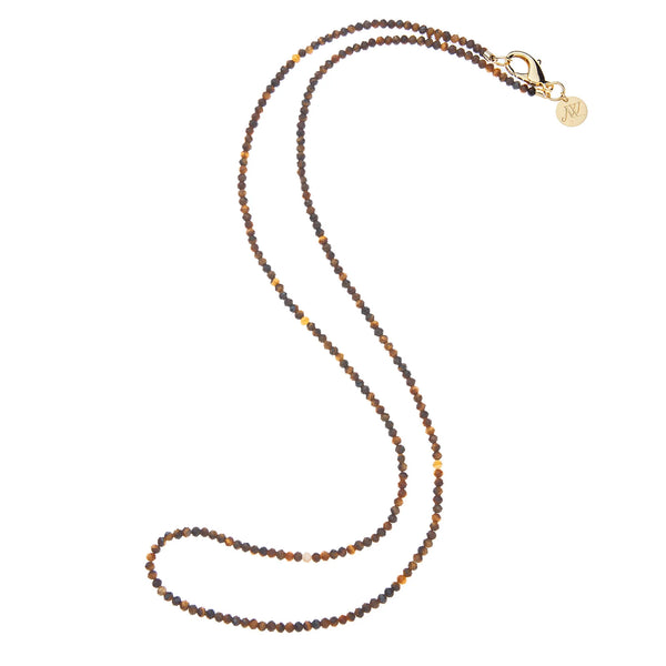 The Jane Win Double Wrap Diamond Cut Beaded Necklace in Tiger's Eye features small round brown and gold beads, a gold plated clasp, and a round gold charm engraved with an N.
