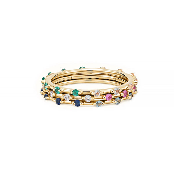 A bright set of gold bangles embellished with colorful gemstones like green, blue, and pink stones, reminiscent of the intricate sparkle found in the Two-Toned Stacker Ring by Kate Collins Jewelry.