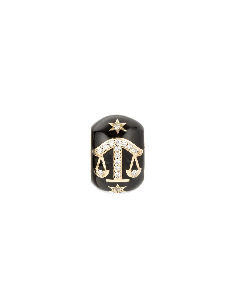 The Adina Reyter Zodiac Ceramic + Diamond Libra Big Bead is a black, rounded ring featuring a gold and diamond-encrusted Libra zodiac symbol with two gold stars, set against a white background—a striking piece of zodiac jewelry.
