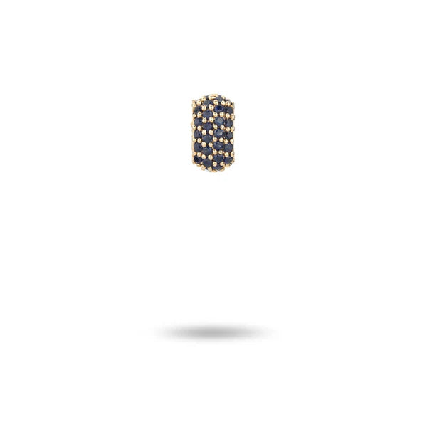 A compact 14k gold earring from Adina Reyter, designed as a Wide Pavé Blue Sapphire Mini Bead. This cylindrical piece, encrusted with deep blue sapphires, is elegantly centered against a plain white background, casting a soft shadow below.