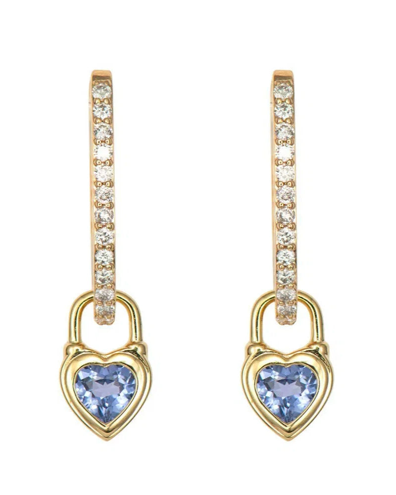Gold hoop earrings by Three Stories Jewelry, featuring Beating Heart Medium Blue Sapphire Charms in 14K Yellow Gold with clear crystals and dangling gold heart-shaped charms with blue sapphire centers—from the Stories of Love Collection.