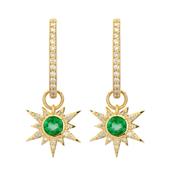 The Three Stories Jewelry Tiny Love Explosion Emerald Charms are 14K yellow gold dangle earrings with star-shaped emerald centers, white topaz rays, and hoops adorned with sparkling white gemstones.