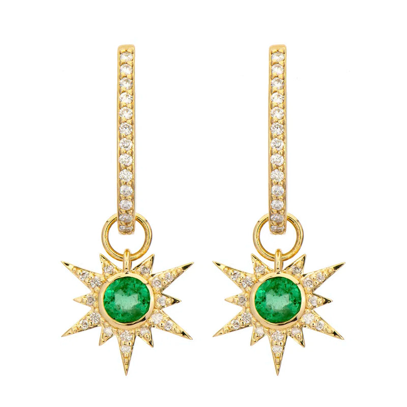 The Three Stories Jewelry Tiny Love Explosion Emerald Charms are 14K yellow gold dangle earrings with star-shaped emerald centers, white topaz rays, and hoops adorned with sparkling white gemstones.