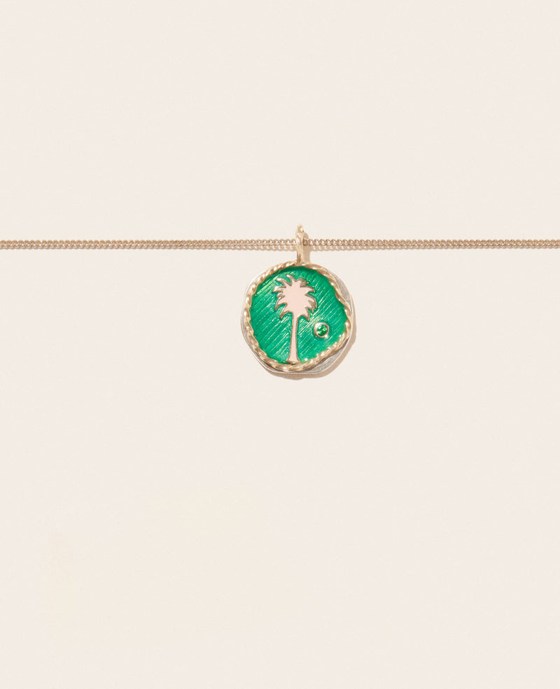 The Pascale Monvoisin Faro Green Pendant is a yellow gold necklace with a circular pendant, featuring a green enamel palm tree and a small Tsavorite gem, shown against a simple light background.