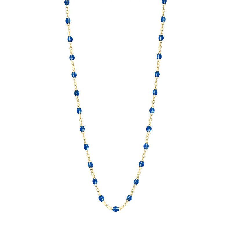 The Gigi Clozeau Classic Gigi 17 Necklace features a gold chain with evenly spaced, small blue resin beads and is shown against a white background.